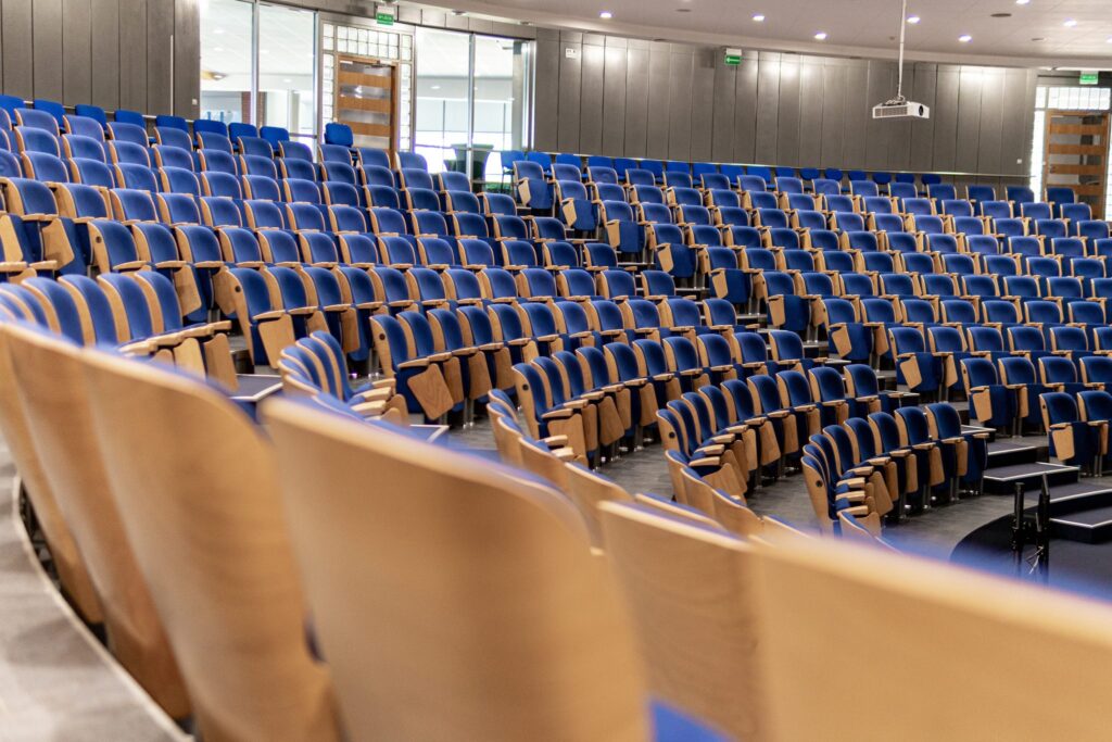 Chaise en bois sans accoudoirs posée contre un mur clair, assise vide vue de face