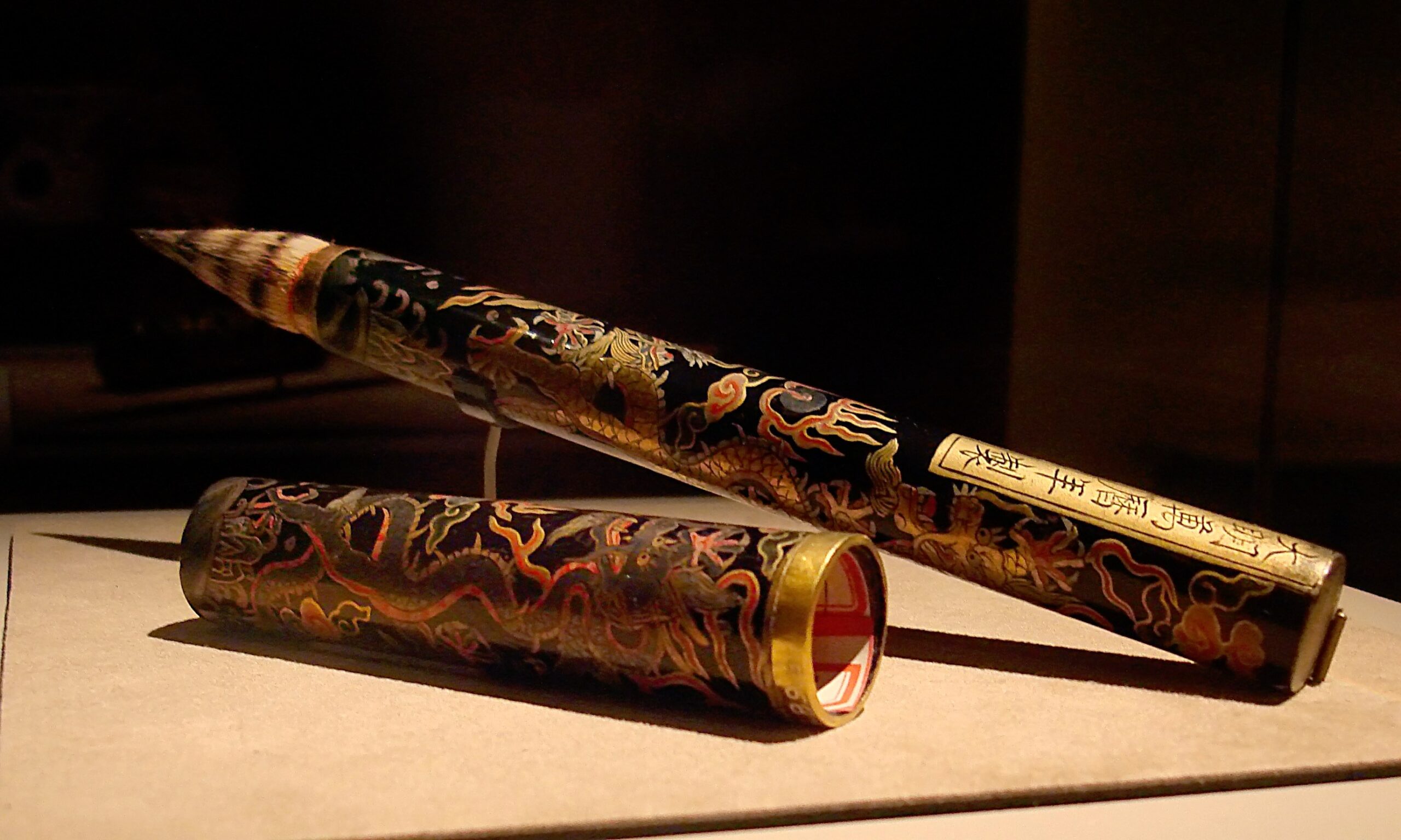 Pinceau de calligraphie posé sur un repose-pinceau à côté d’un encrier et d’une feuille vierge