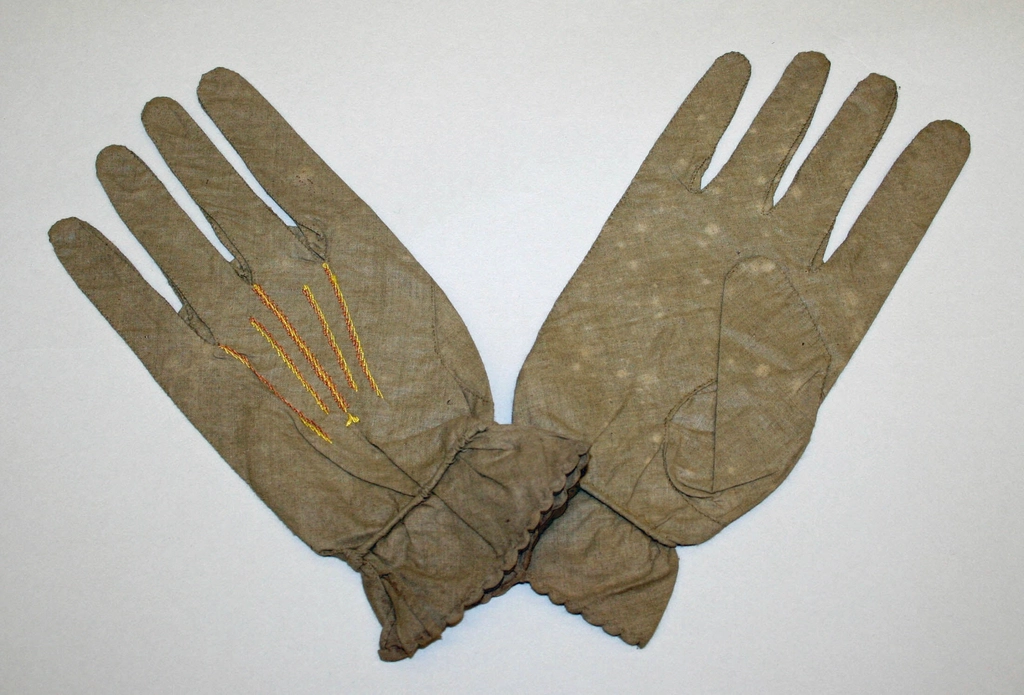 Paire de gants en coton blanc posée à côté d'une boîte de rangement fermée